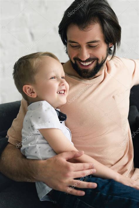 Retrato De Padre Feliz Abrazando A Su Hijo Pequeño En El Sofá En Casa 2022