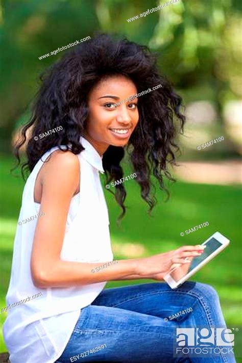 outdoor portrait of a smiling teenage black girl using a tactile tablet african people stock