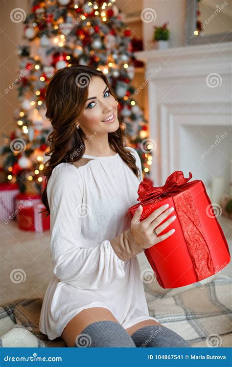 beautiful slender brunette girl in a santa hat sits smiling and stock image image of person
