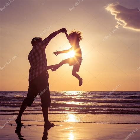 Father And Son Playing On The Beach At The Sunset Time Stock Photo By