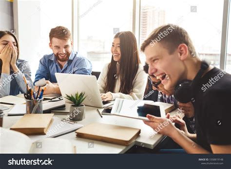 Young People Enjoying Group Study In College Library Sitting With