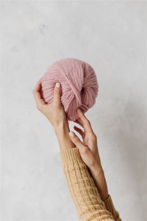 Person Holding Yarn Rolls · Free Stock Photo