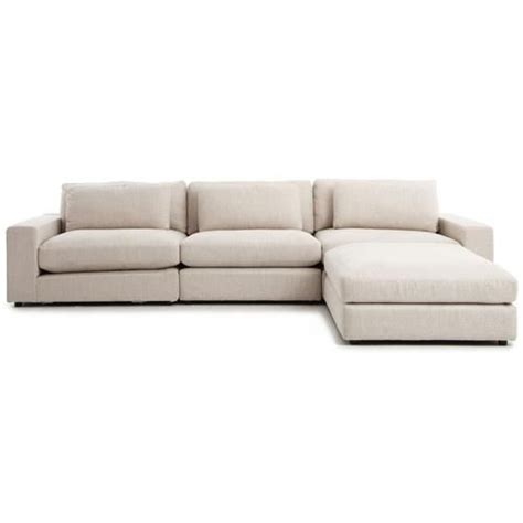 A White Sectional Couch Sitting On Top Of A White Floor