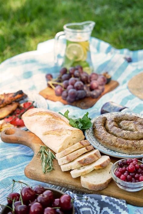 Picnic Homemade Sausage Bread Fruits Are Arranged On Tablecloths On