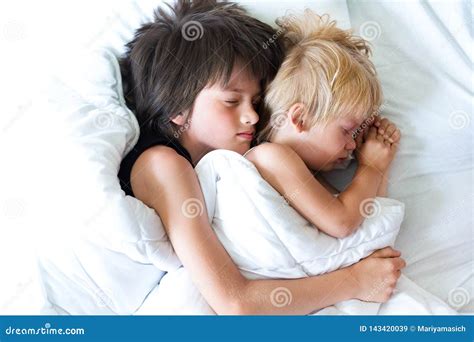 Happy Brother With Little Brother Lying In A Bed Together Kissing And Hugging Siblings Stock