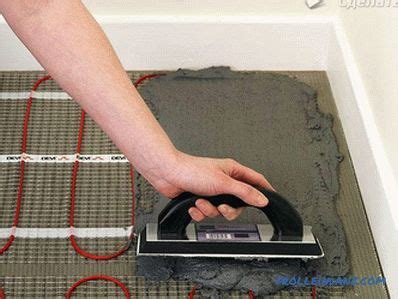 Die elektrische fußbodenheizung bringt wärme sonnengleich in den raum ein. Elektrische Fußbodenheizung mit den Händen unter der ...