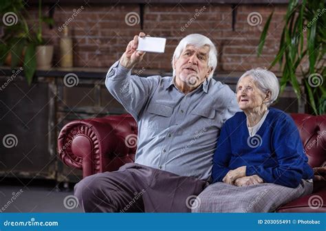 Senior Couple Taking Selfie With Smart Phone While Sitting On Couch Stock Image Image Of Home