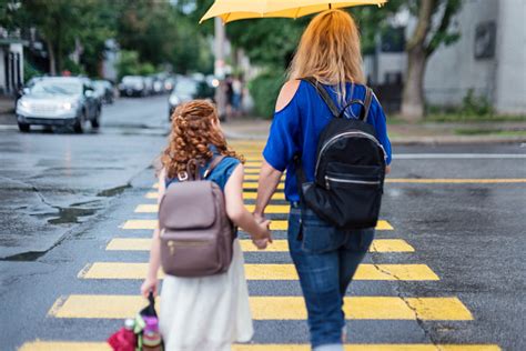 Mother And Daughter Walking To School In City Street Morning Stock