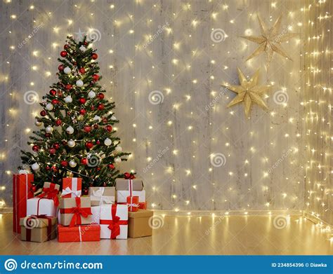 christmas tree and heap of t boxes and copy space over grey wall with festive led lights