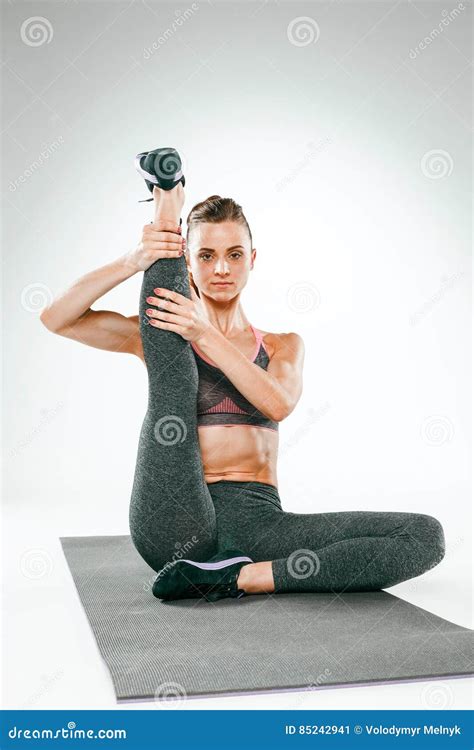 Beautiful Slim Brunette Doing Some Stretching Exercises In A Gym Stock