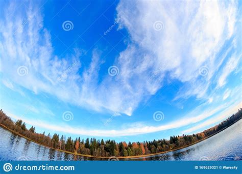 Autumn Sky Near The Lake With Forest Clouds And Reflections In Water