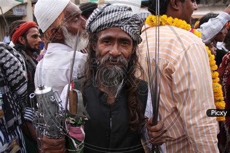 image of an indian muslim devotee performs a stunt as he takes part in the religious procession