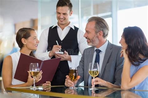 Waiter Taking The Order From A Businessman And His Colleagues Stock