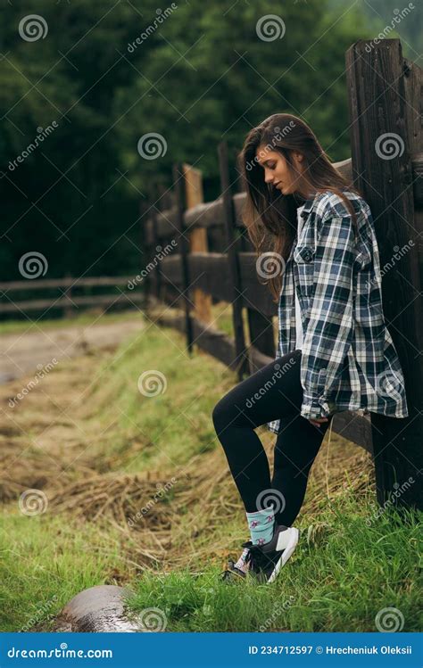 A Young Attractive Caucasian Female Stand By A Fence Stock Image