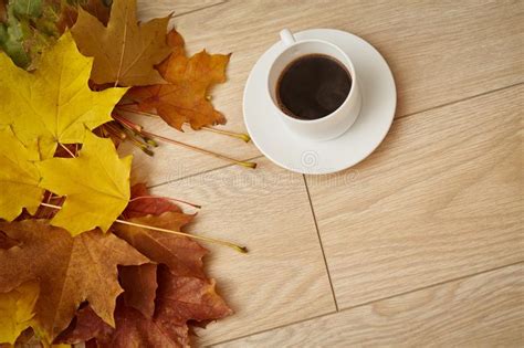 Cup Of Coffee With Yellow Autumn Leaves On Wooden Background Stock
