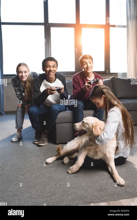 Happy Multicultural Teenagers Playing Video Games With Joysticks At