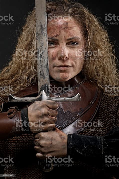 Portrait Of Blonde Viking Warrior Female Holding A Sword In Studio Shot