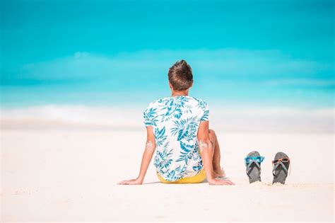 Mulher Deitada Na Praia Aproveitando As Férias De Verão Olhando Para O Mar Foto Premium
