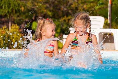 Two Happy Little Girls Splashing Around In The Pool — Stock Photo