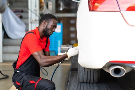 Premium Photo Black Man Mechanic Working Under A Vehicle In A Car