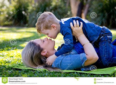 Mother And Young Son Embracing And About To Kiss Whilst Playing Stock