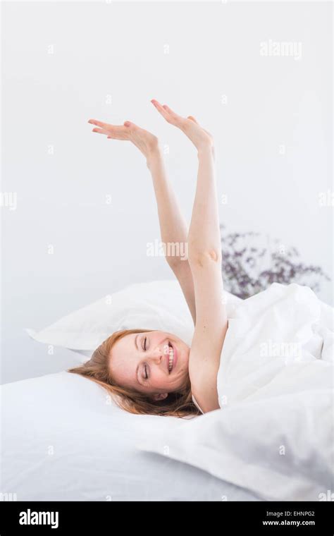 Woman Waking Up And Stretching In Bed Stock Photo Alamy