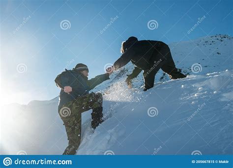 Climber Assists Another Climber On The Slope Of Snowy Mountains Stock