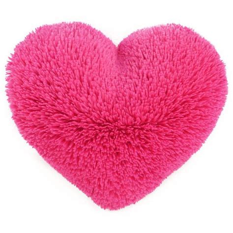A Pink Heart Shaped Pillow Sitting On Top Of A White Surface