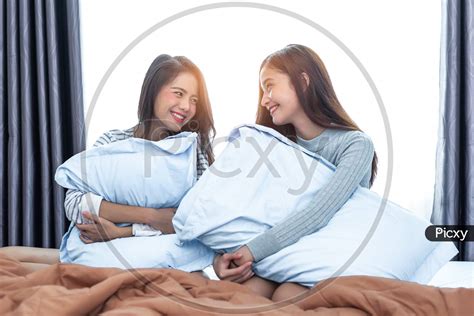 Image Of Two Asian Lesbian Women Looking Together In Bedroom Couple