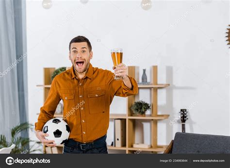 Handsome Man Modern Living Room Screaming While Holding Football Ball