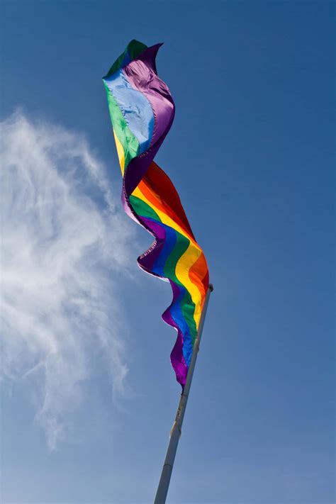 Download A Rainbow Flag Flying In The Wind Wallpaper