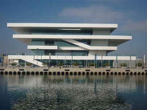 A Large White Building Sitting Next To A Body Of Water