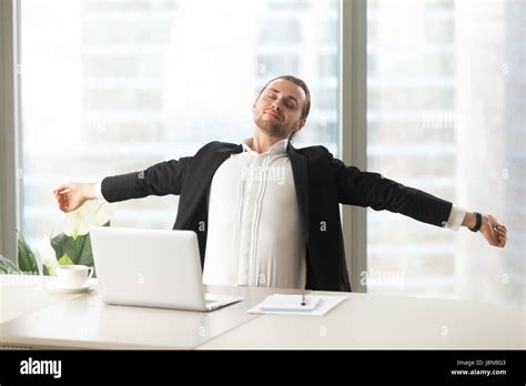 Businessman Stretching Out At Desk With Laptop Office Worker Doing