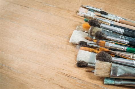 Bunch Of Old Artist Paintbrushes On Wooden Rustic Table With Space For
