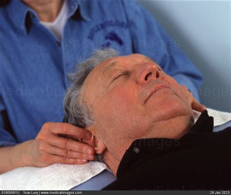 Stock Image Close Up Of A Man Receiving Massage Therapy On His Ears By Aprofessional Masseur