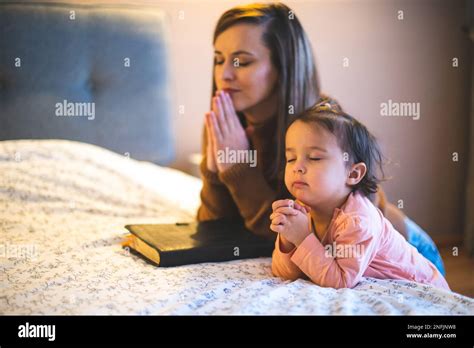 Madre Y Su Hija Leyendo De La Biblia Y Orando De Rodillas Cerca De La