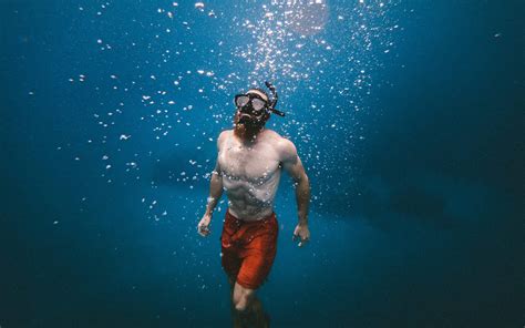 Download Man Swimming Upward Under Ocean Wallpaper