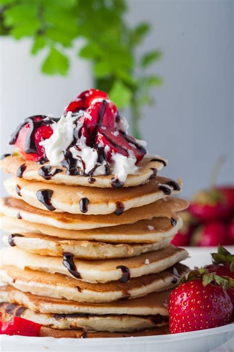 Stack Of Pancakes With Strawberries Whip Cream And Chocolate Syrup On