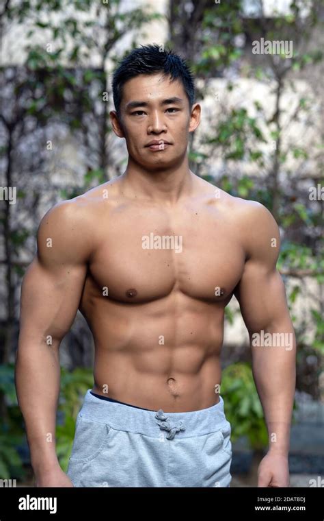Un homme musclé japonais amateur bodybuilder pose à l extérieur dans un