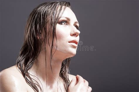 closeup portrait of caucasian sensual brunette touching neck and showing wet and shining skin