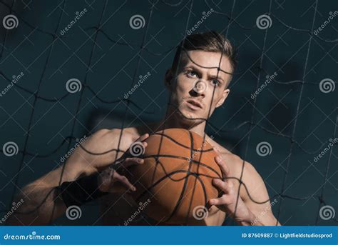 Concentrated Sporty Man Holding Basketball Ball In Hands Stock Image