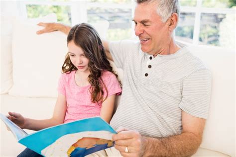 Smiling Grandfather And Granddaughter Reading Book Stock Image Image