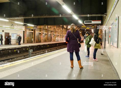 passengers waiting for tube train on london underground station platform hi res stock