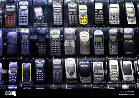 Old Mobile Phones On A Technology Market Showcase Cell Phones From The