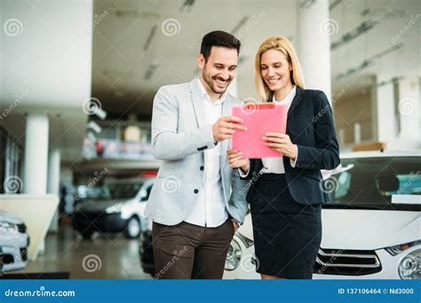Professional Salesperson During Work With Customer At Car Dealership