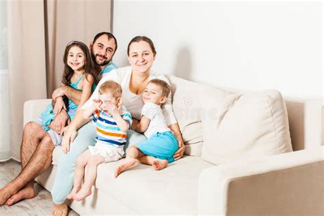 Happy Parents With Kids Are Sitting On The Sofa Stock Photo Image Of