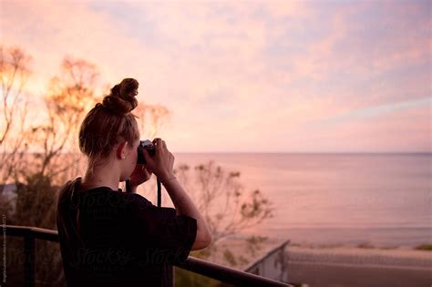 Teenage Girl Taking Photos Of A Sunset At The Beach By Angela Lumsden