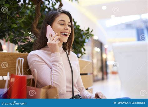 Excited Woman Talking By Mobile Phone In Shopping Mall Stock Photo