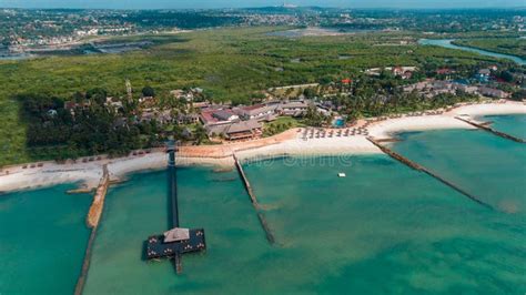 Aerial View Of An Amazing Beach With A Pier And Palm Trees By The