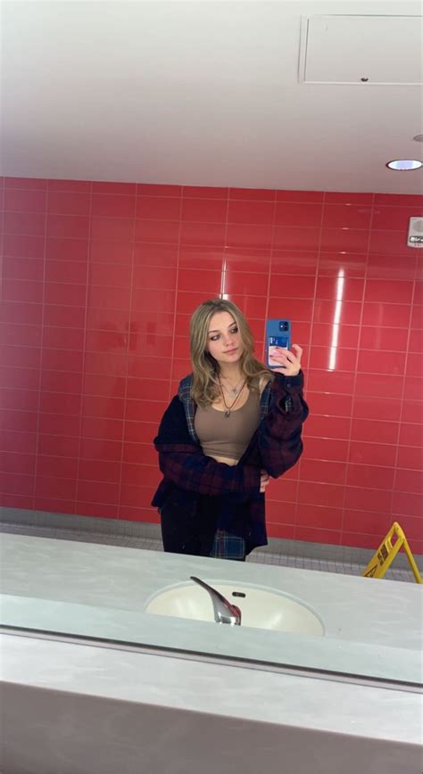 A Woman Taking A Selfie In Front Of A Red Tiled Bathroom Counter With A